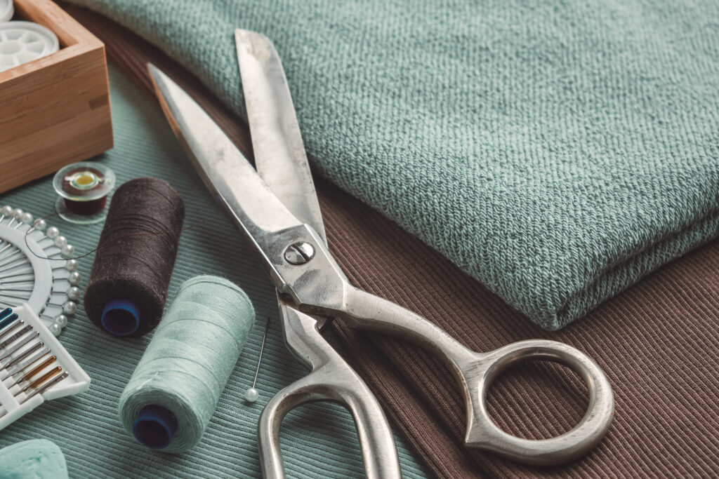 Scissors, thread and fabric for commercial custom cut and sew services.